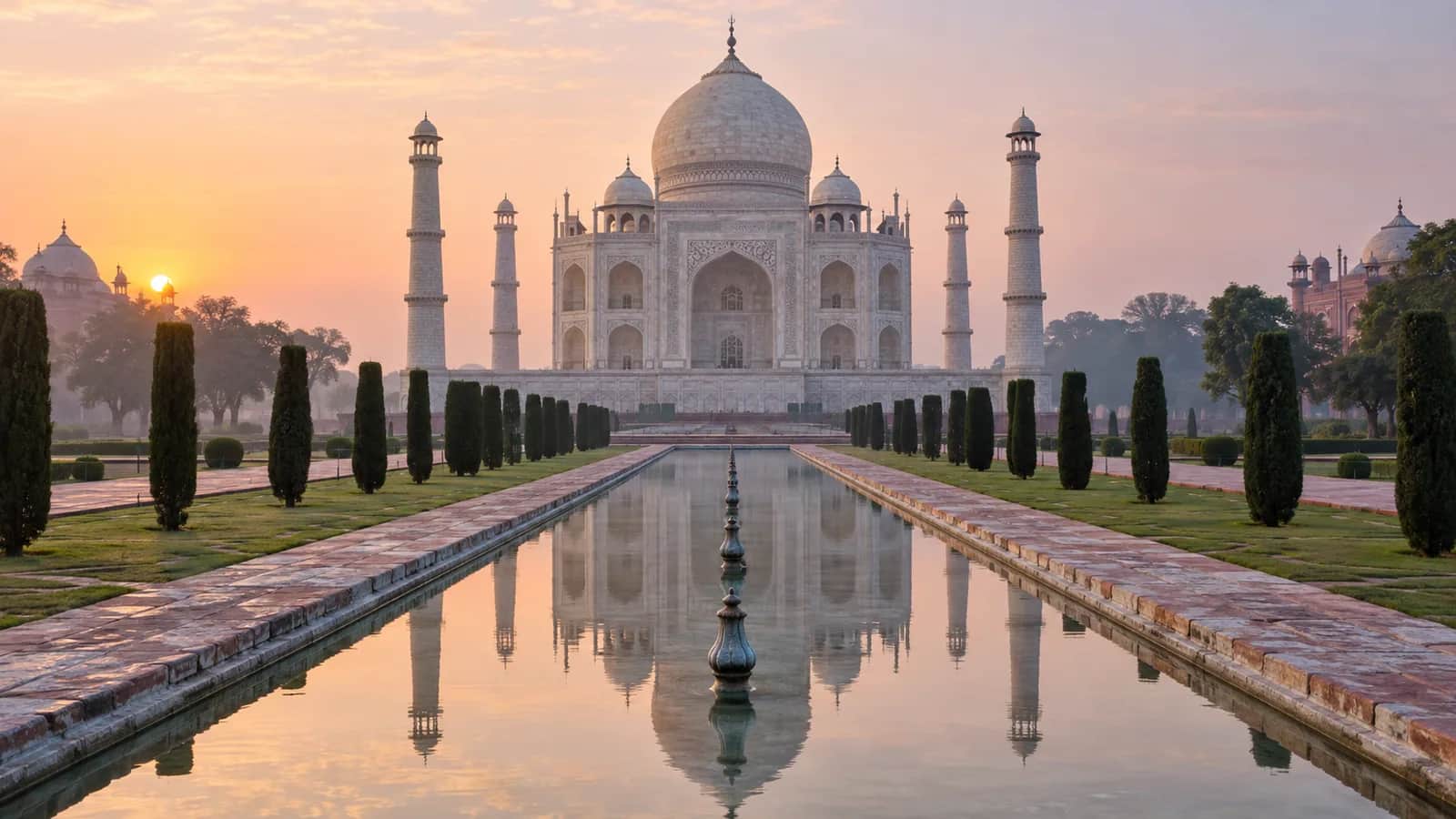 The Taj Mahal reflected in its central garden pool at dawn in Agra