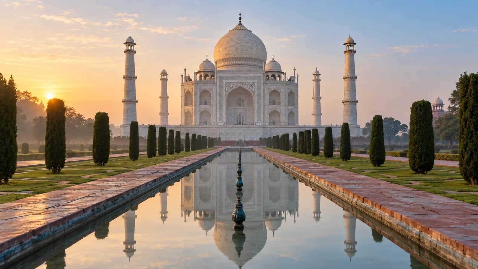 The Taj Mahal and its reflection in the central garden pool at dawn in Agra