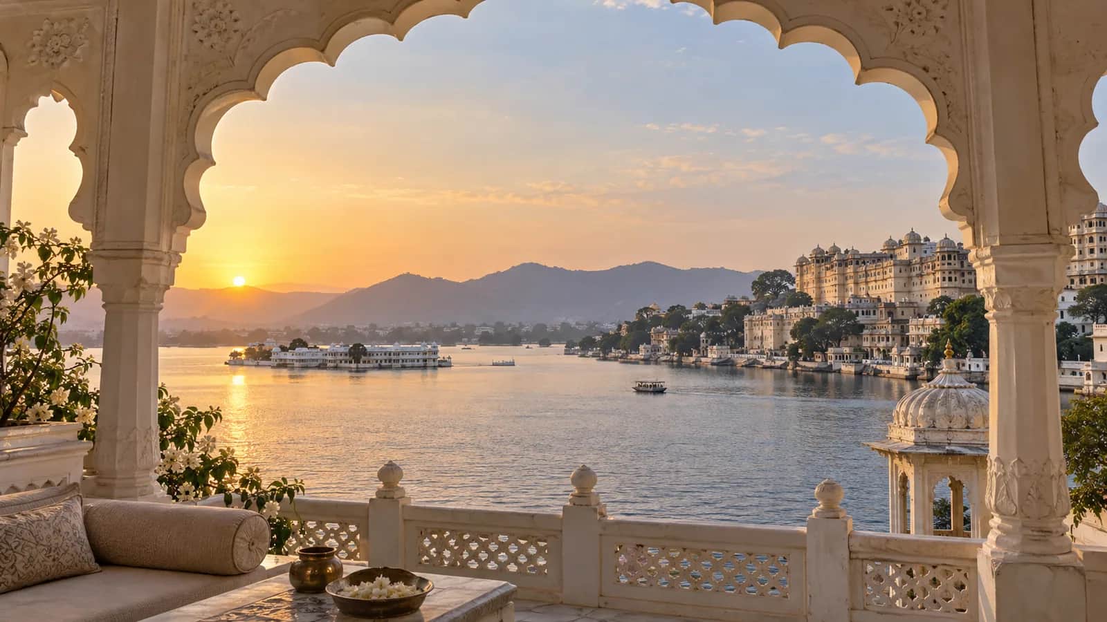 Udaipur City Palace and Lake Pichola framed by a white haveli arch at sunrise