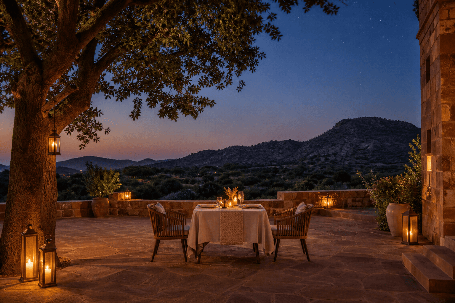 A lantern-lit two-place dinner beneath a native tree in a Jaipur heritage courtyard