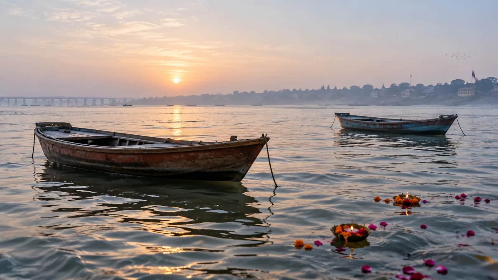 Wooden boats and flower offerings on the Triveni Sangam at Prayagraj at sunrise