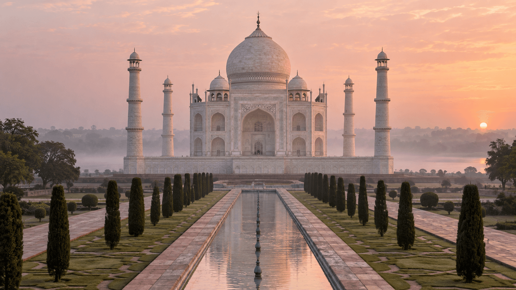 The Taj Mahal at sunrise above soft Yamuna River mist in Agra